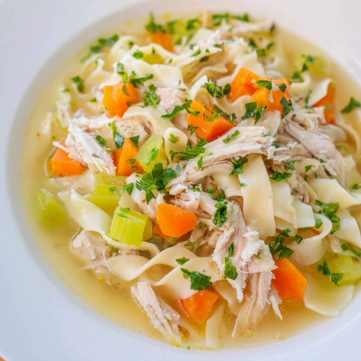 A warm bowl of Chicken Noodle Soup with Homemade Noodles, filled with tender chicken, carrots, celery, and silky noodles.
