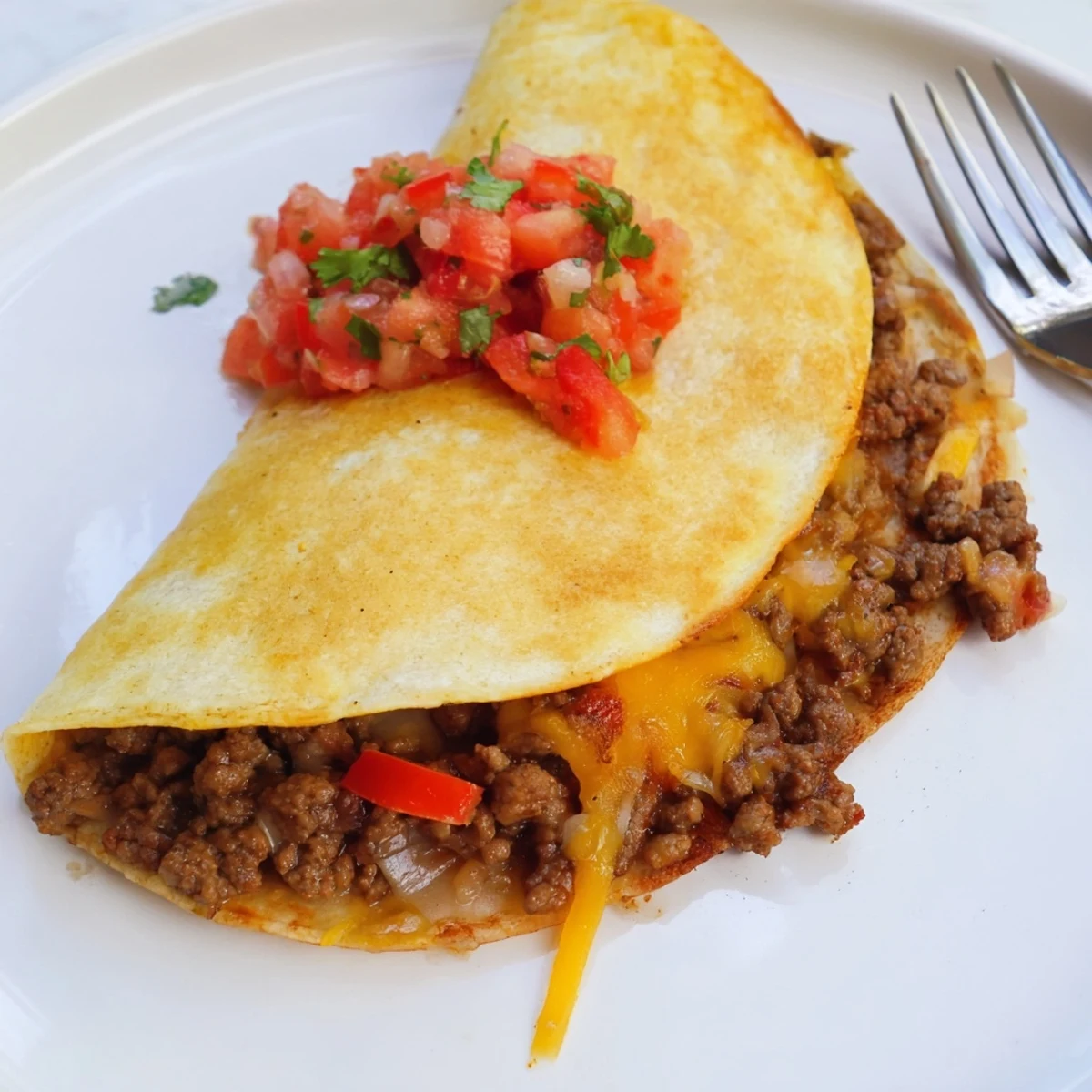 Golden, crispy flour tortillas stuffed with seasoned ground beef and melted cheddar, served beside fresh salsa and creamy guacamole.