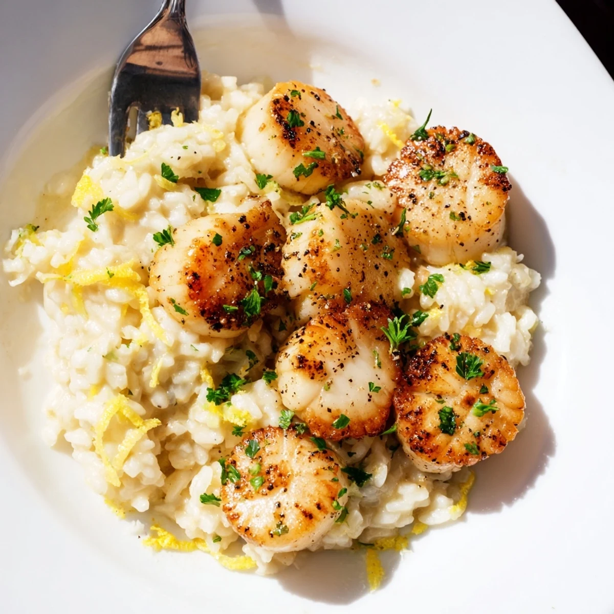 Creamy Parmesan risotto serves as a bed for pan-seared Lemon Garlic Scallops with Risotto.