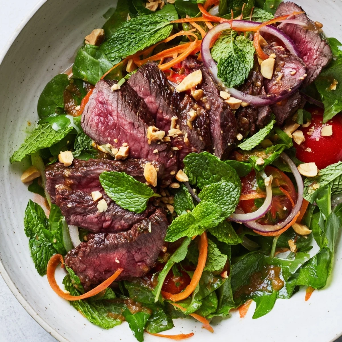 Juicy marinated beef slices rest atop a bed of crisp watercress, cucumber, and carrot in this Vietnamese Beef and Watercress Salad.