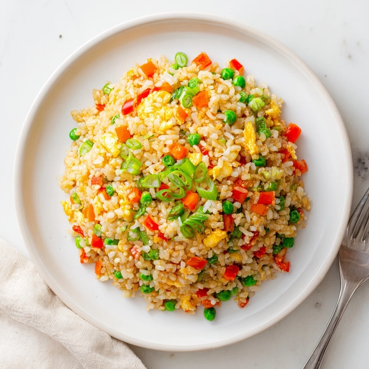 Golden scrambled eggs and crisp bell peppers mix into fluffy jasmine rice, creating a vibrant Fried Rice dish ready to serve hot.  