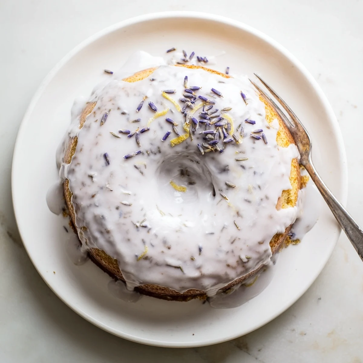 Golden Lemon Lavender Cake slice showing drizzled glaze and lavender buds, ready to serve with tea.