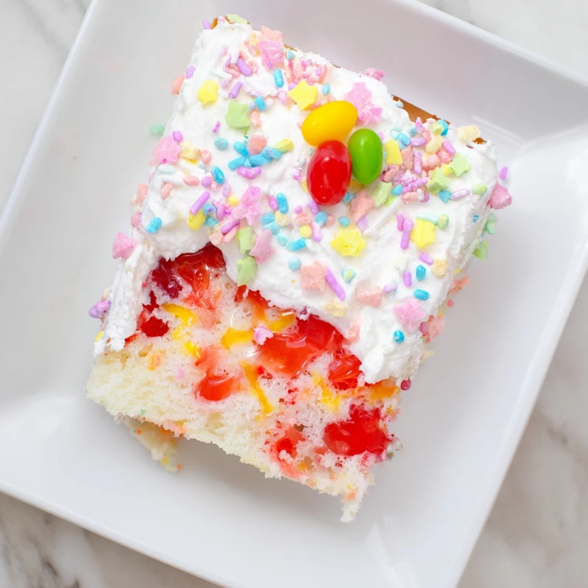 Easter Poke Cake with vanilla gelatin showing colorful holes and fluffy whipped cream topping