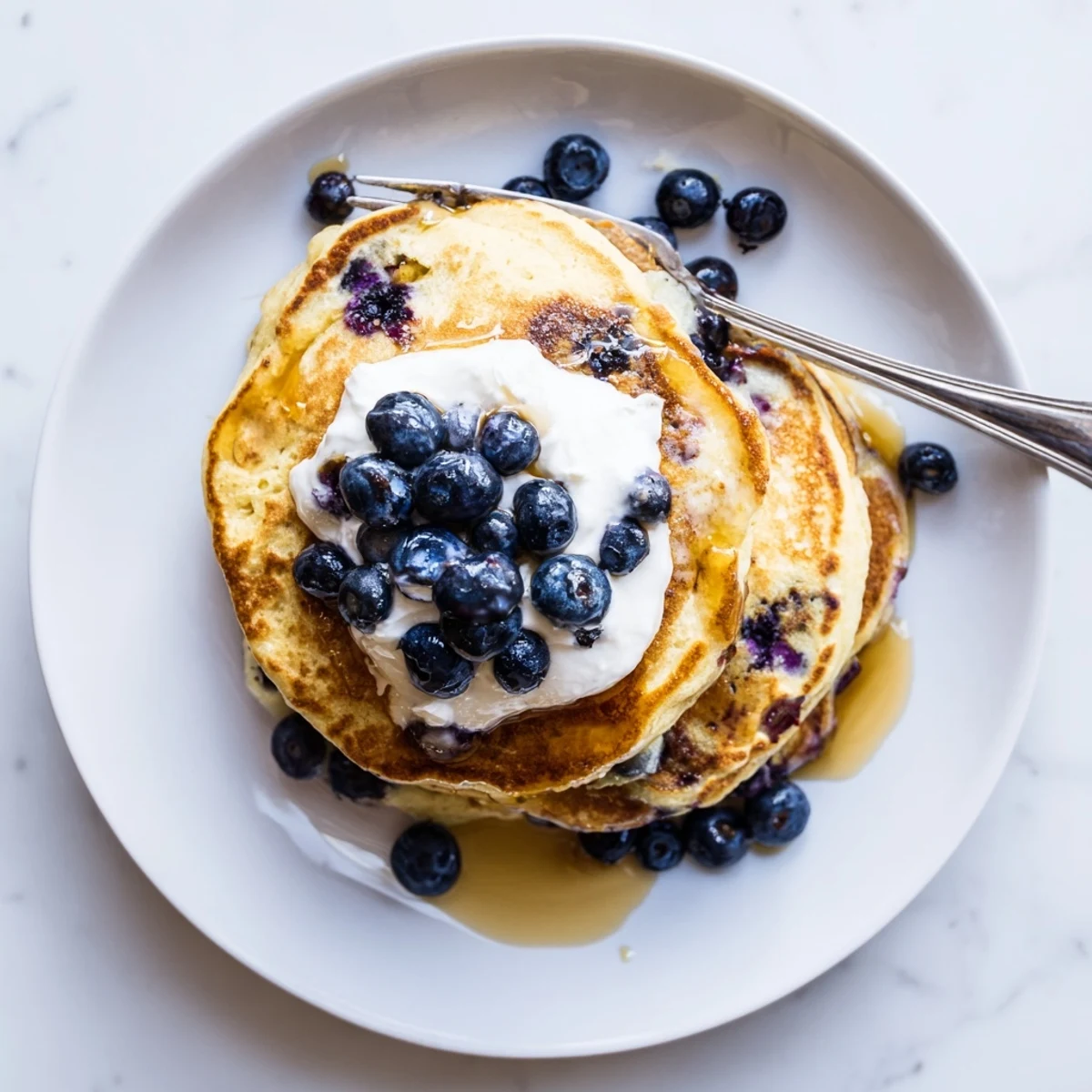 Close-up of thick protein-rich Greek yogurt blueberry pancakes studded with juicy purple blueberries