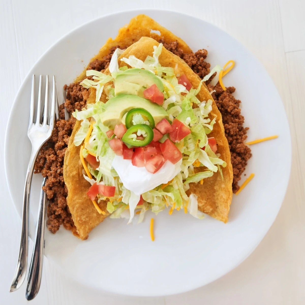 Golden keto crunchwrap featuring seasoned beef, melted cheddar, fresh lettuce, and creamy low-carb tortilla