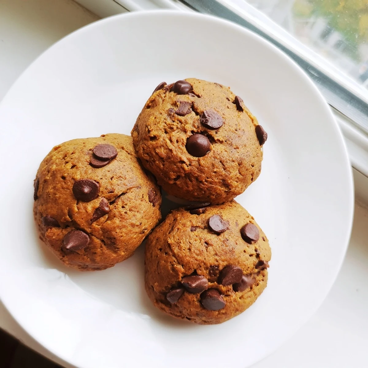Warm pumpkin spice chocolate chip cookies fresh from the oven with golden edges and gooey centers