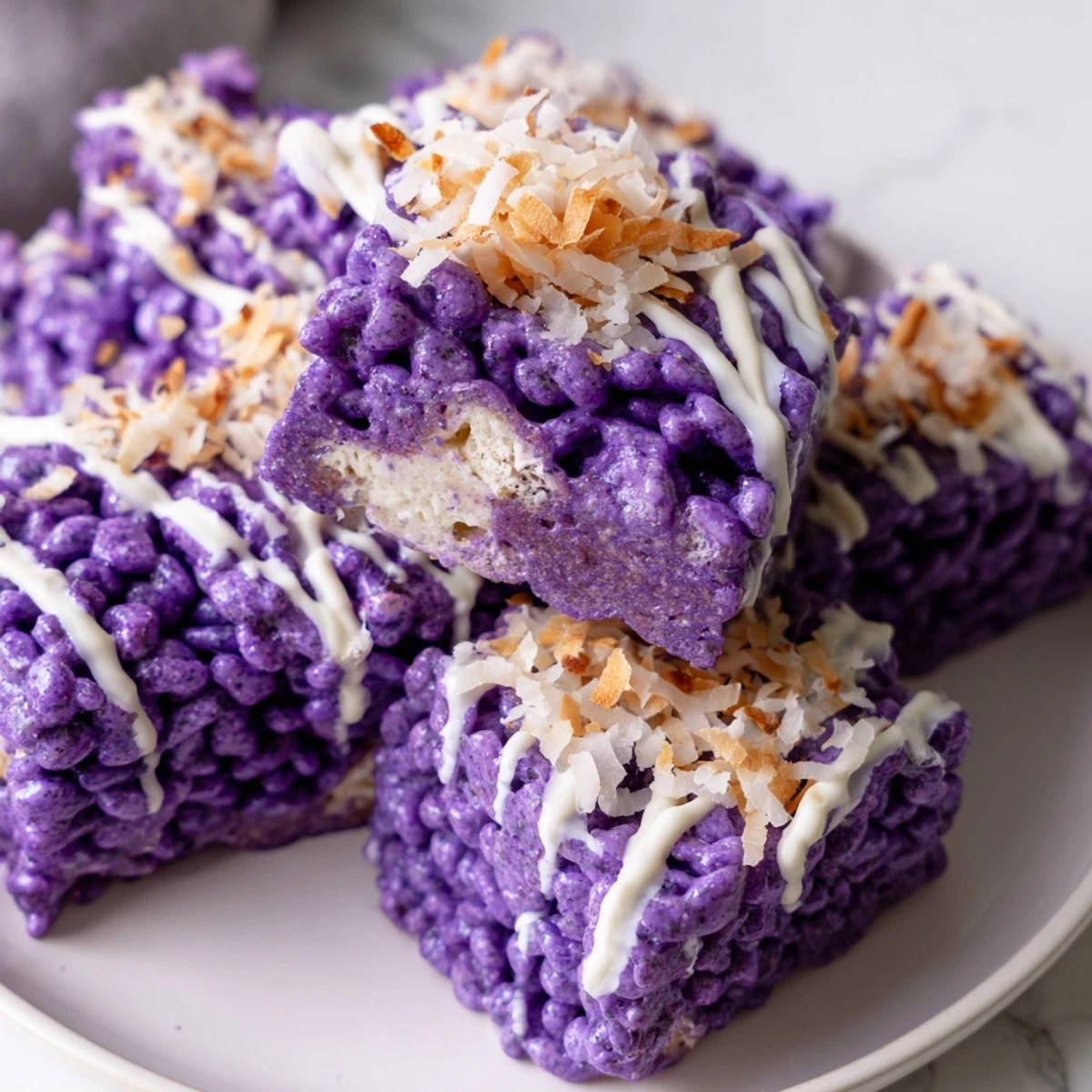 Homemade ube rice krispie treats cut into squares with toasted coconut topping