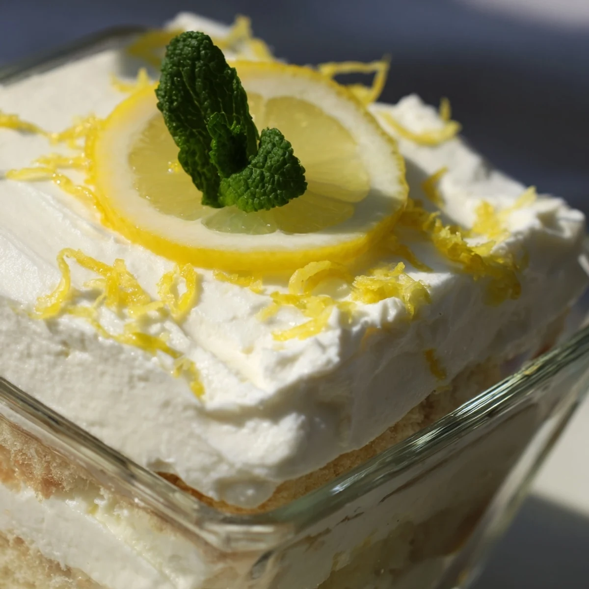 Fresh lemon tiramisu layered with lemon-soaked ladyfingers and creamy mascarpone topped with bright lemon slices