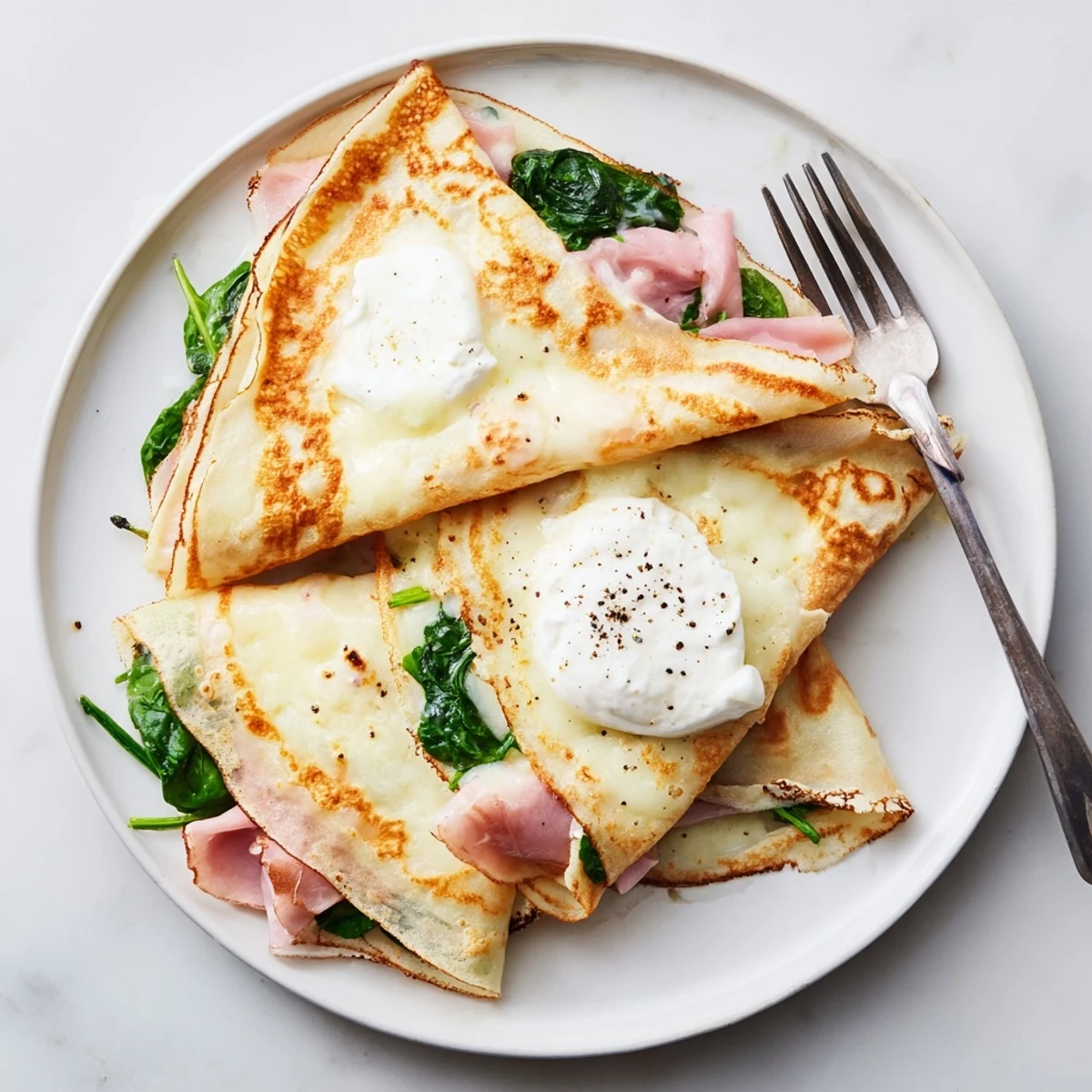 Thin French savory crepes rolled with creamy spinach and Swiss cheese filling