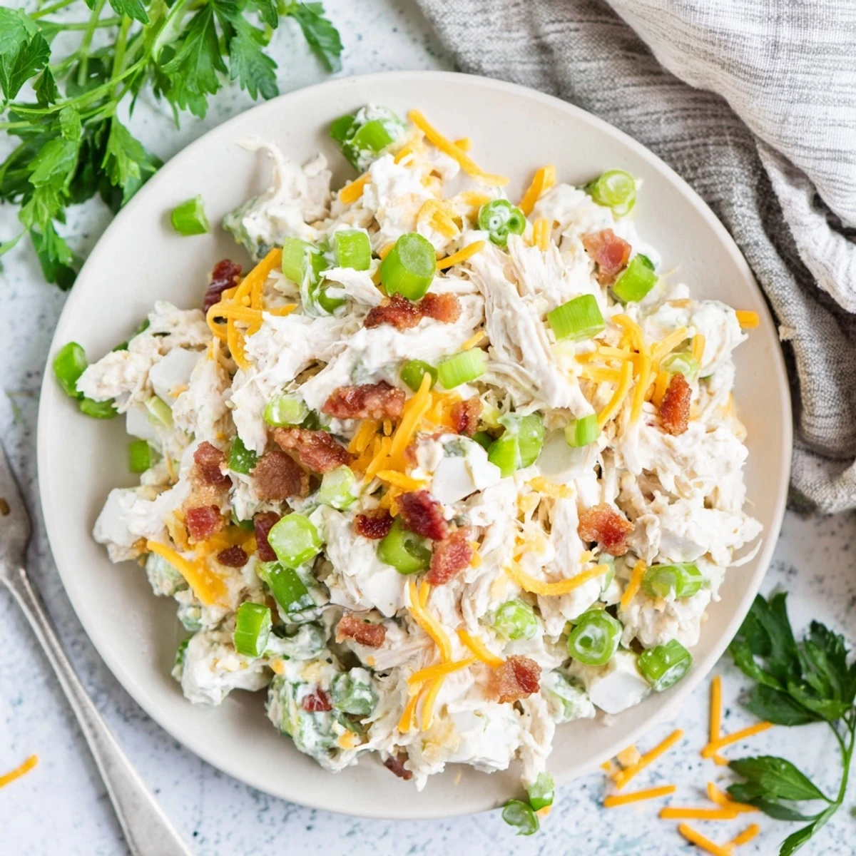 Protein-rich low carb jalapeno popper cottage cheese chicken salad plated with vibrant jalapeño pieces, bacon crumbles, and a creamy white dressing coating the tender chicken