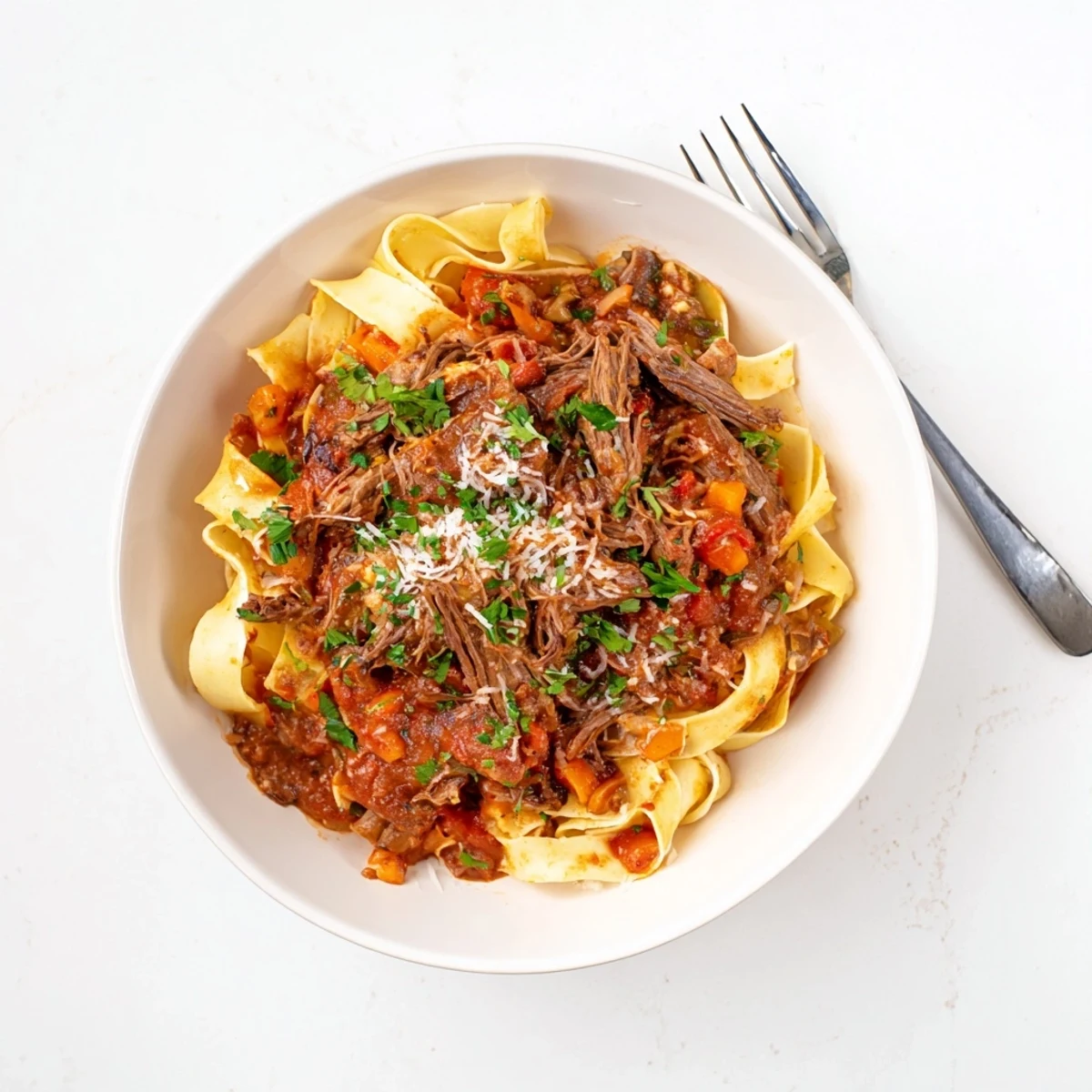 Hearty slow cooker beef ragu featuring fork-tender beef chunks in a savory red wine tomato sauce