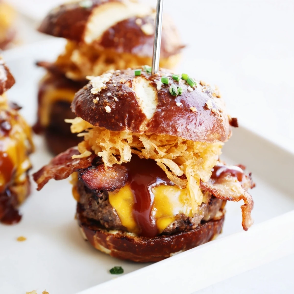 Juicy pretzel cowboy sliders stacked with melted cheddar, crispy bacon, and tangy barbecue sauce on toasted pretzel buns