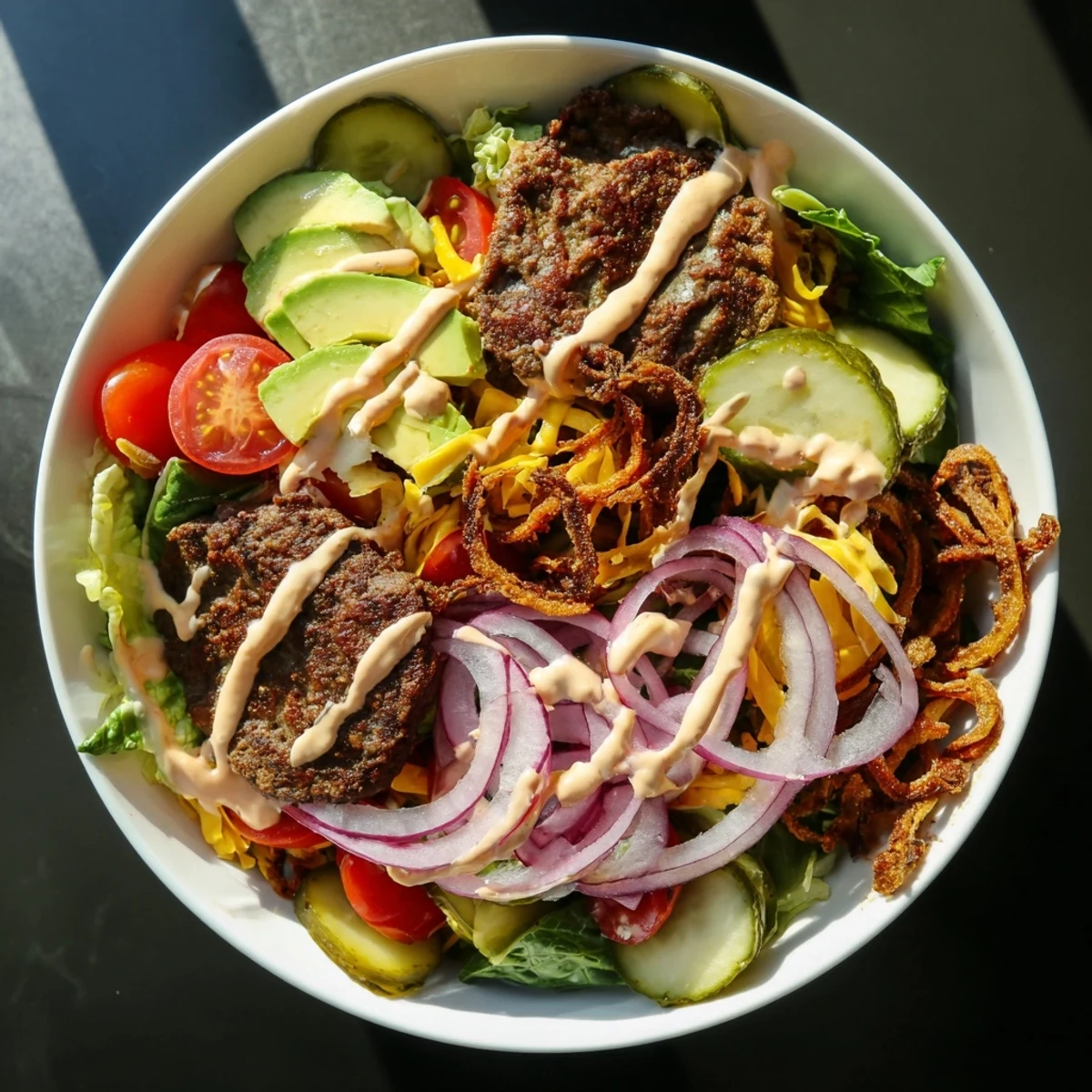 Satisfying gluten-free smash burger bowl with crisp-edged patties, shredded cheddar, dill pickles, and fresh salad vegetables