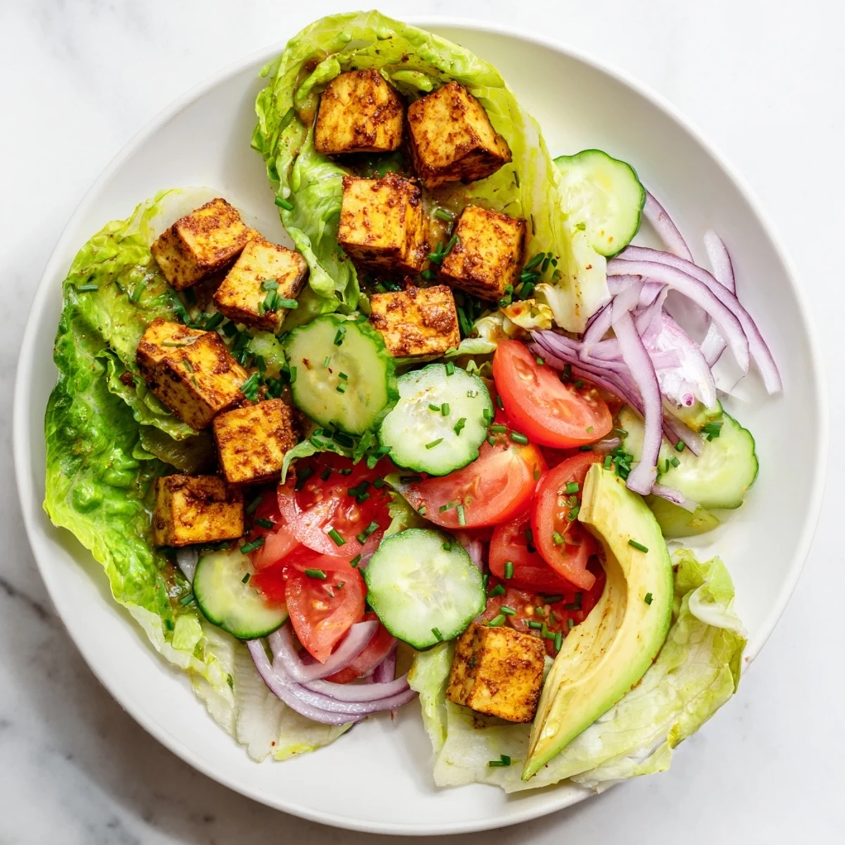 Golden smoky tofu cubes served over crisp romaine lettuce with juicy ripe tomato slices and fresh herbs