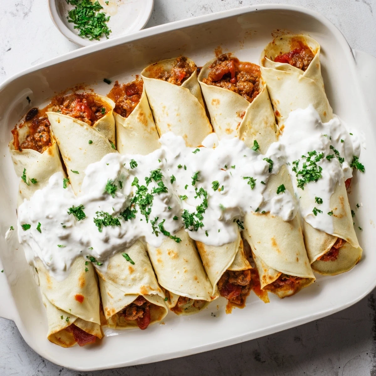 Golden Hungarian Hortobágyi palacsinta filled with spiced meat ragout and creamy sour cream sauce