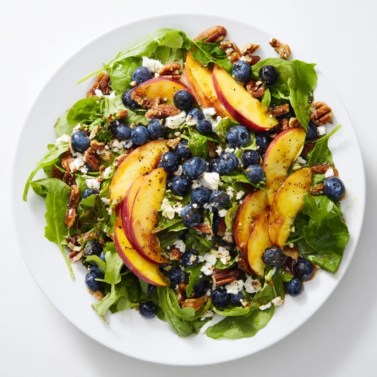 Fresh blueberry peach feta salad with juicy ripe peaches and creamy crumbled feta over mixed greens