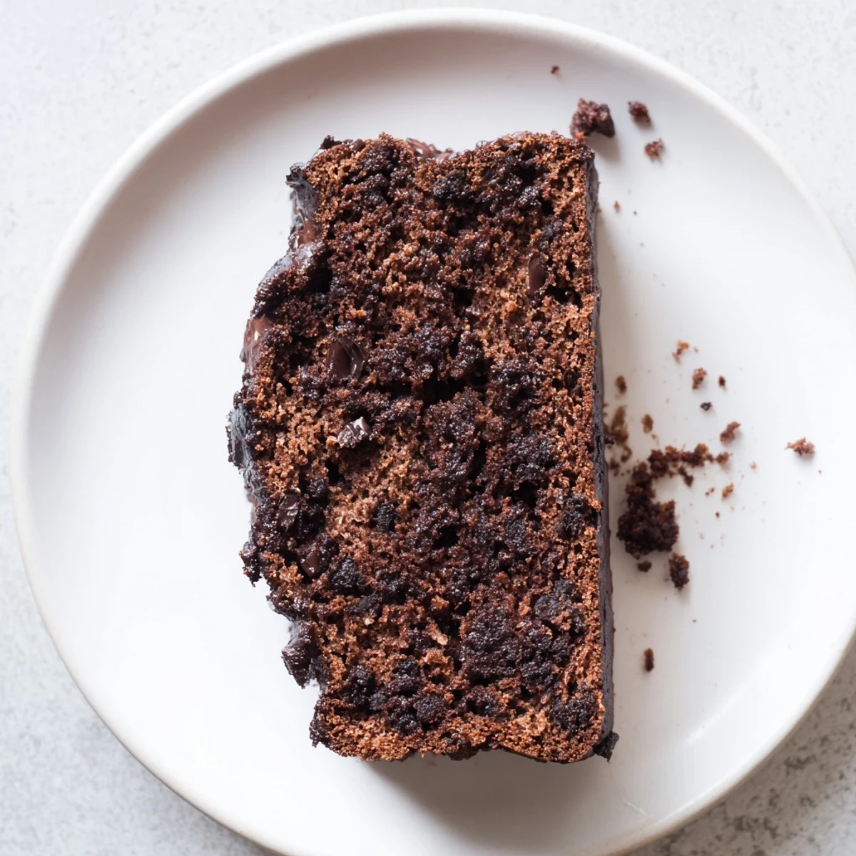Moist chocolate espresso banana bread loaf studded with melty chocolate chips on a wooden board