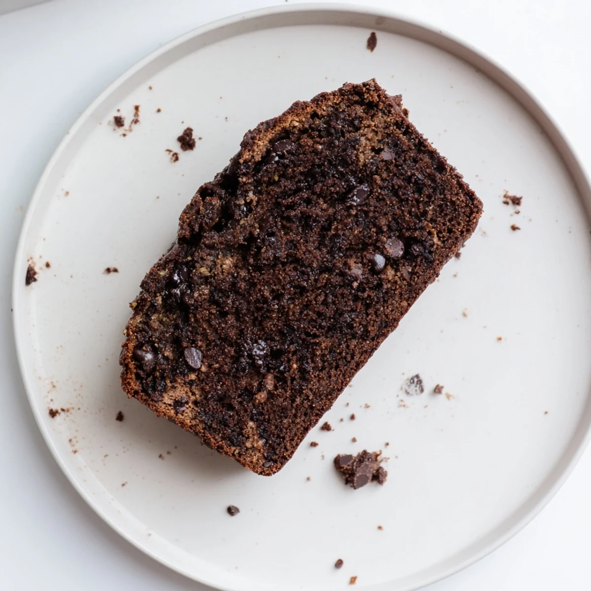 Slice of rich chocolate espresso banana bread revealing dark cocoa crumb and chocolate chip pockets