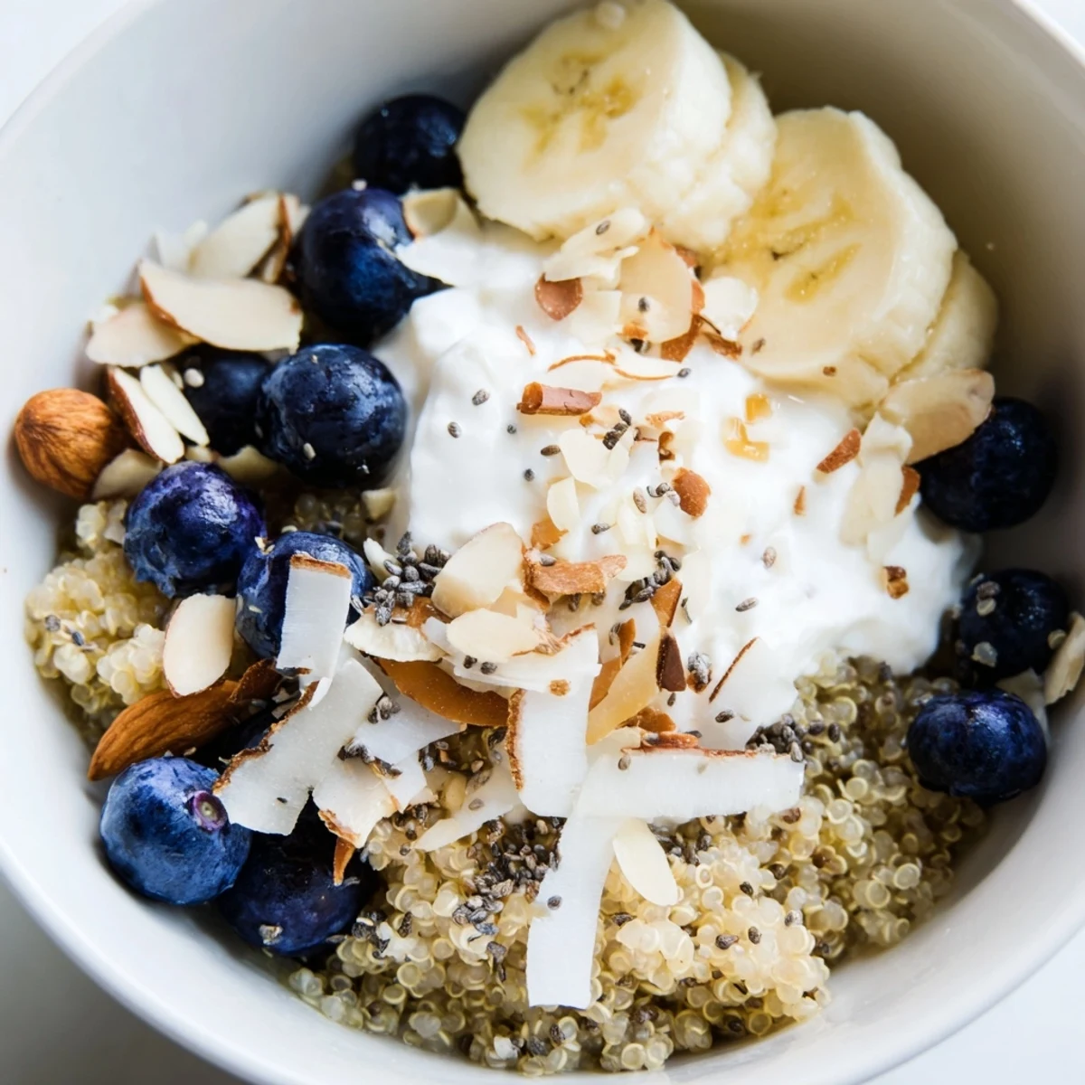 Protein-packed blueberry quinoa breakfast bowl drizzled with maple syrup and sprinkled with chia seeds