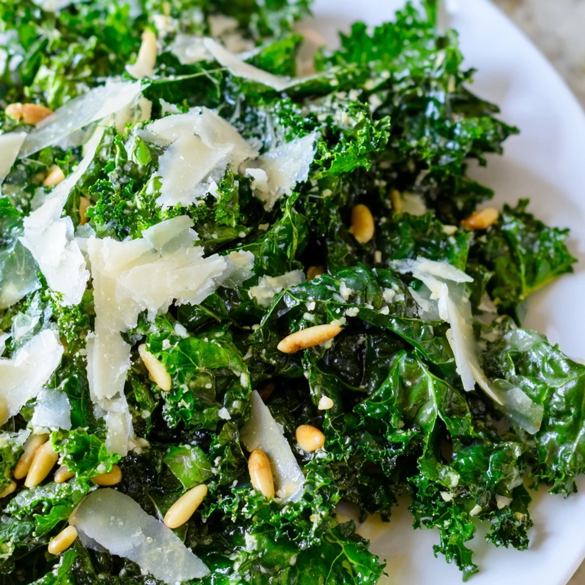 Fresh kale leaves glistening with zesty garlic lemon dressing and topped with Parmesan