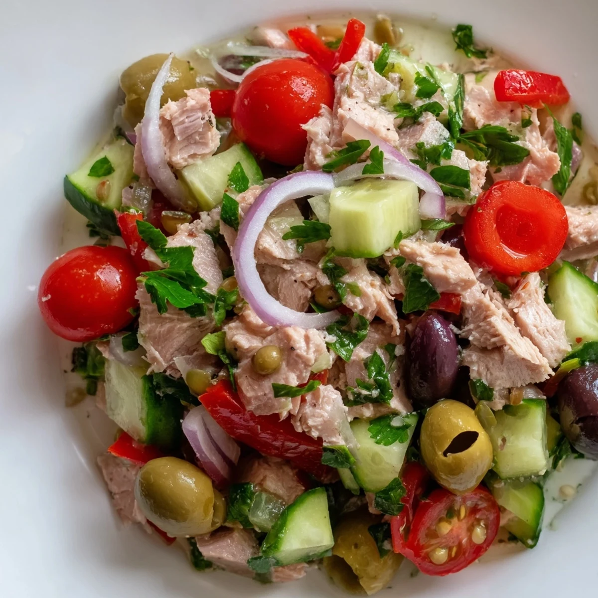 Simple Mediterranean Tuna Salad served on a rustic plate with Kalamata olives and peppers
