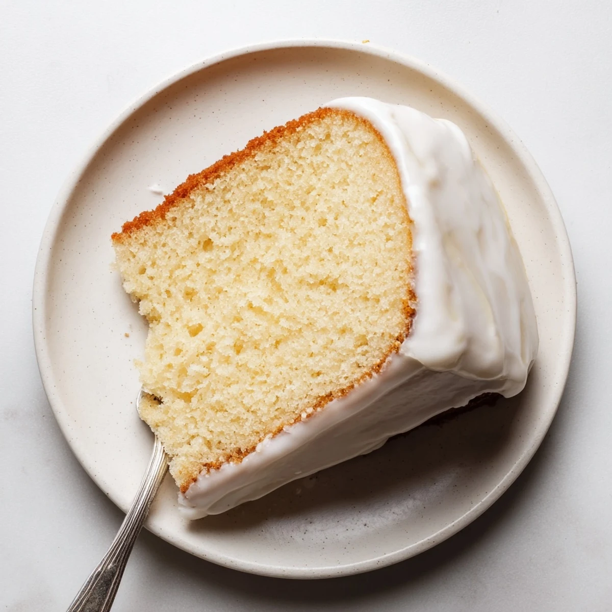 Golden church cake with vanilla glaze drizzled over a tender moist sponge ready to serve