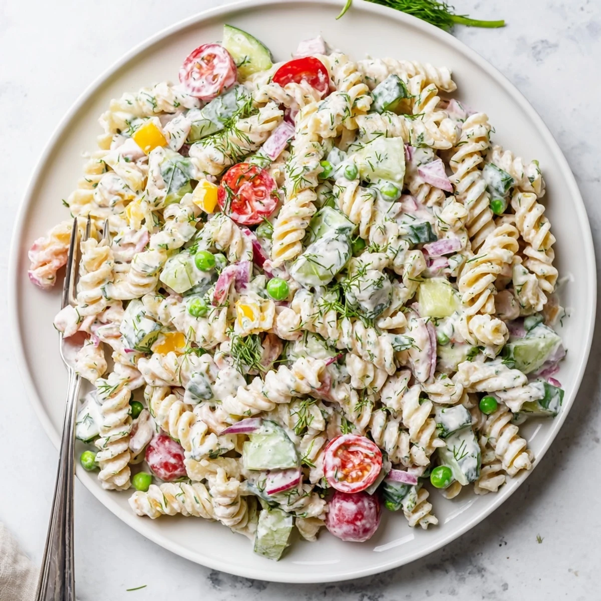 Chilled creamy ranch pasta salad featuring vibrant cherry tomatoes, crunchy cucumber, and bell pepper tossed in tangy sauce