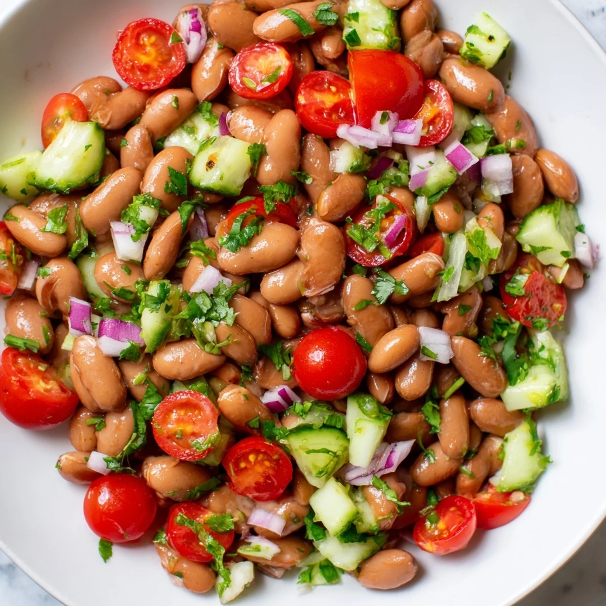 Colorful pinto bean salad tossed with crisp veggies and zesty lime dressing