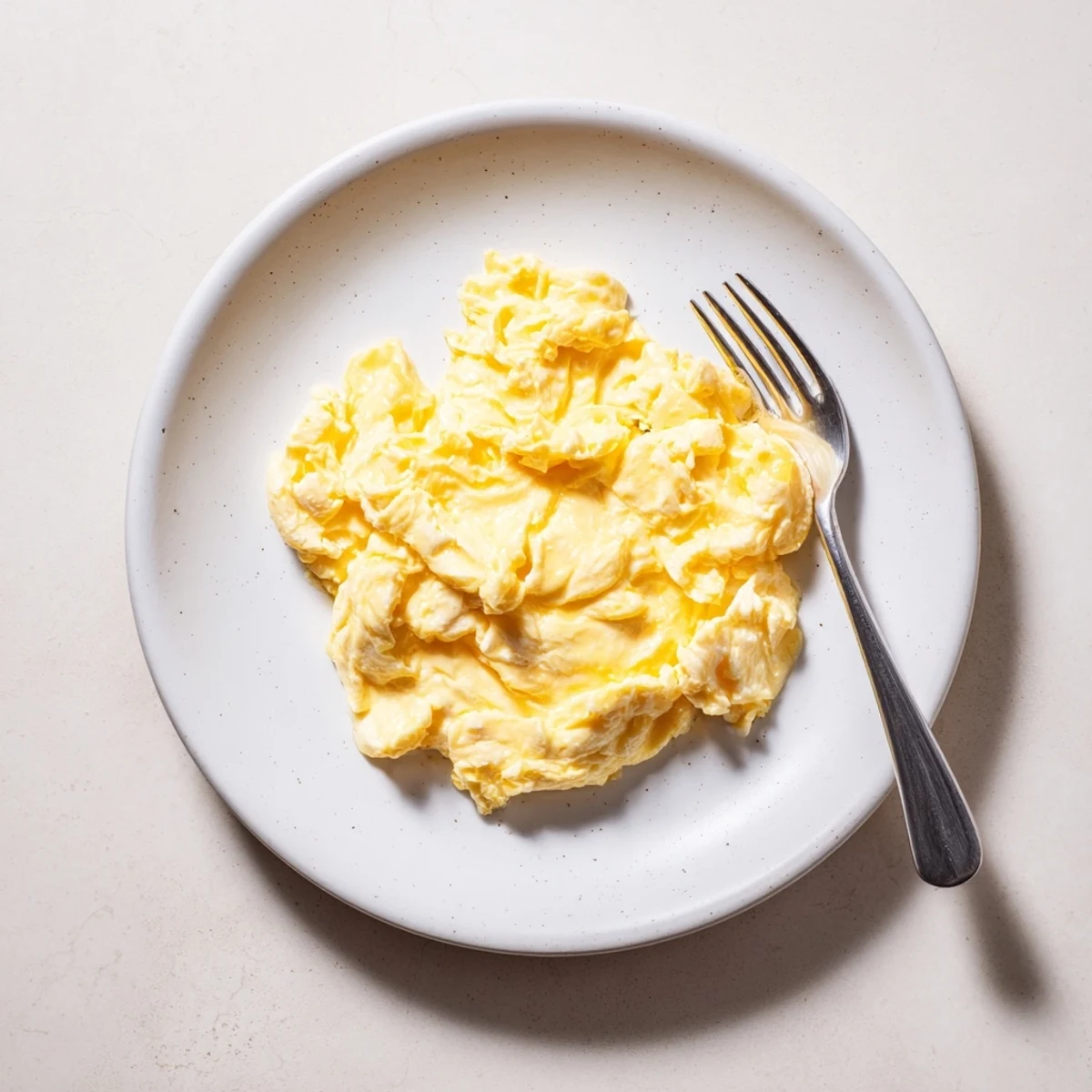 Fluffy scrambled eggs gently folded with melted butter in a nonstick skillet