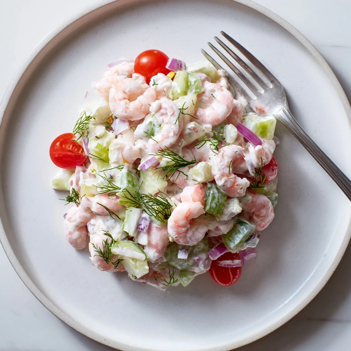 Pink shrimp salad recipe tossed in creamy lemon dill dressing in bowl