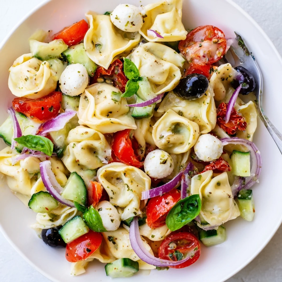 Tortellini Pasta Salad with glossy cherry tomatoes and basil, chilled picnic ready