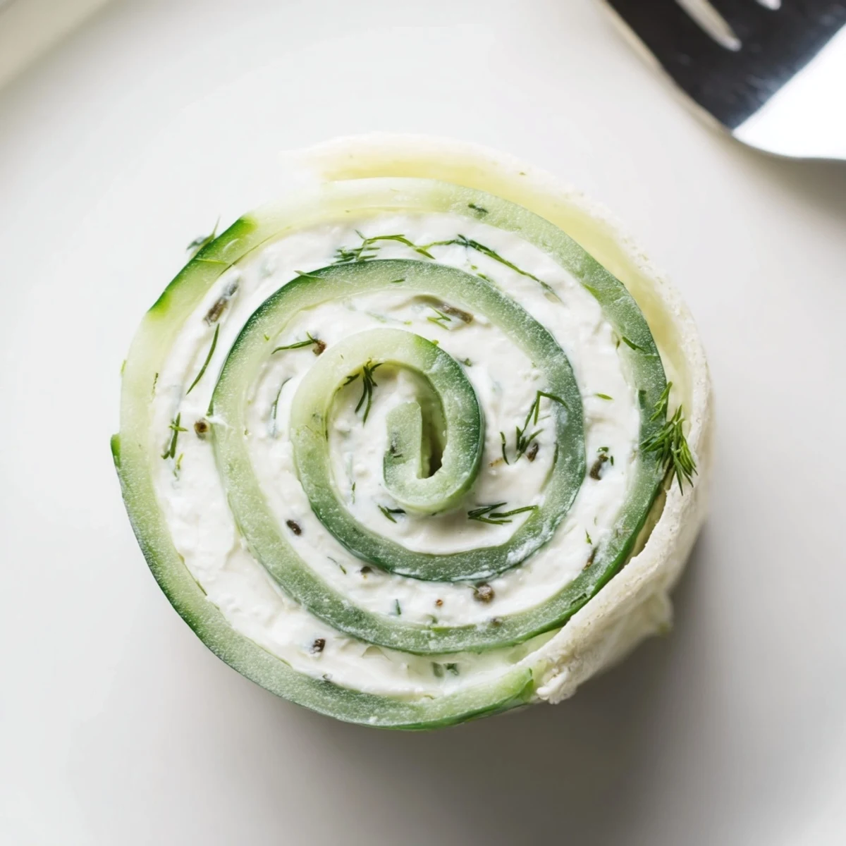Cucumber And Dill Pinwheels arranged on platter, crisp cucumber and creamy filling