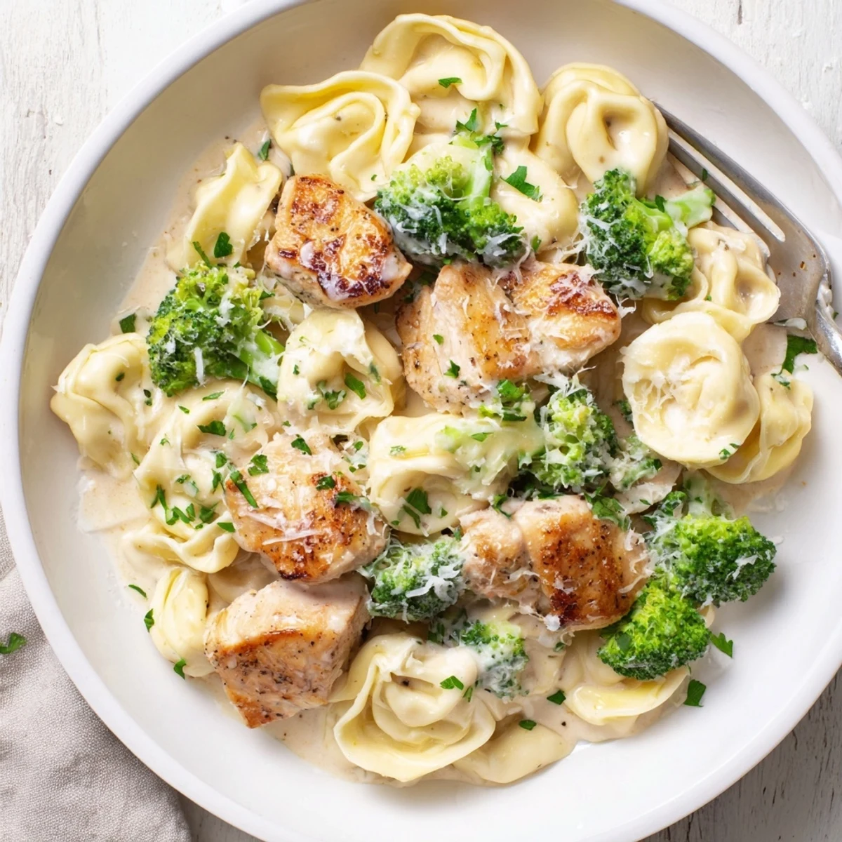 Creamy Garlic Parmesan Tortellini Chicken Broccoli Recipe steaming in skillet, rich garlic aroma