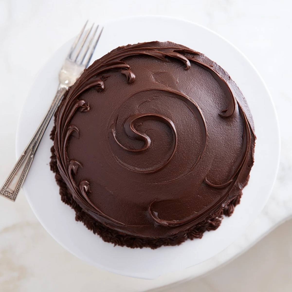 Slice of fudgy Matilda chocolate cake topped with creamy buttercream and chocolate ganache dripping