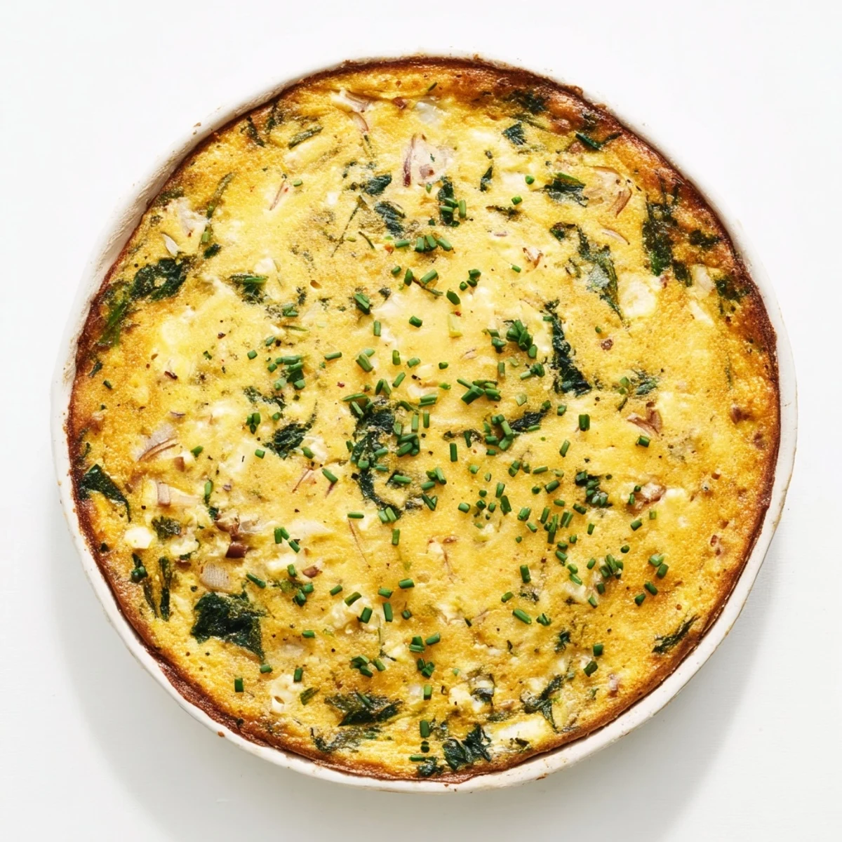Protein-rich crustless quiche featuring melted cheddar and wilted spinach fresh from the oven