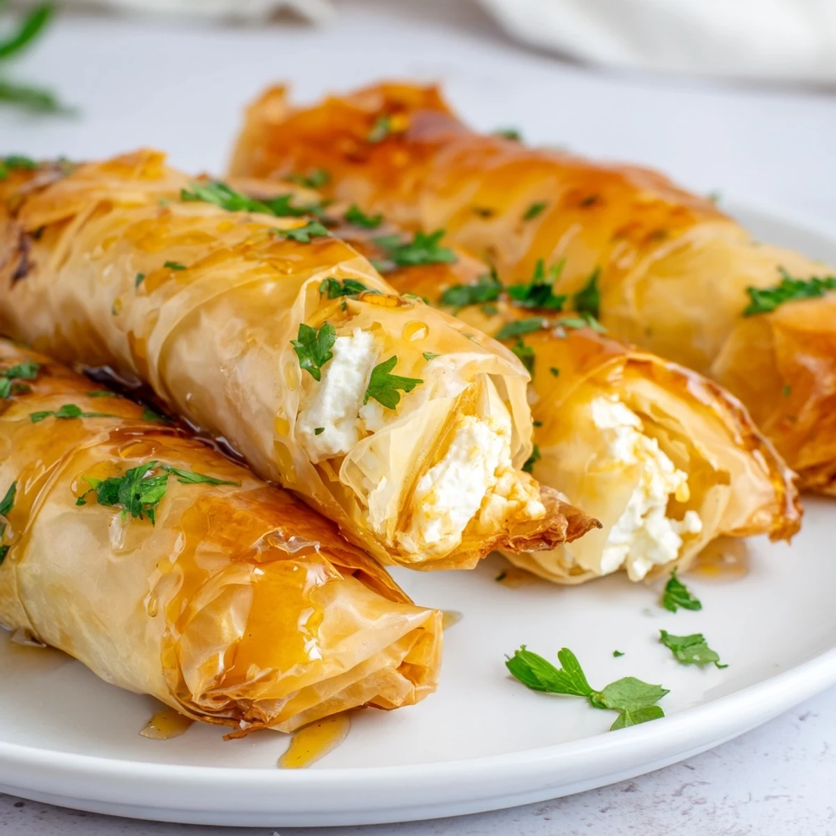 Mediterranean appetizer of golden feta rolls brushed with olive oil and chili honey drizzle