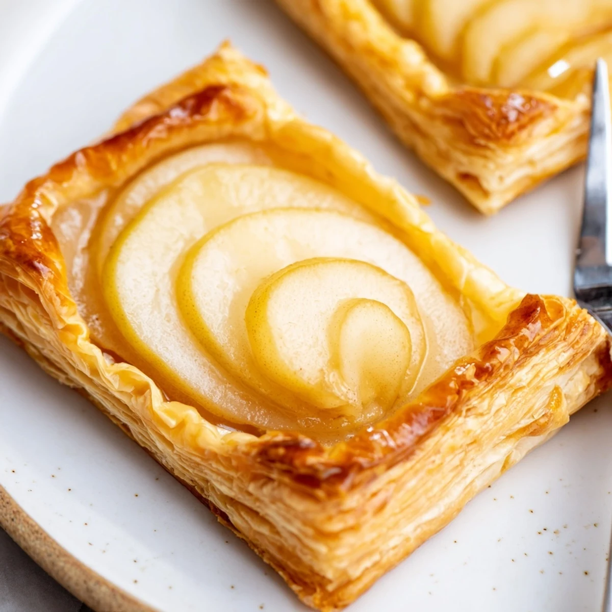 Baked Pear Puff Pastry Recipe cooling on parchment, edges puffed and browned