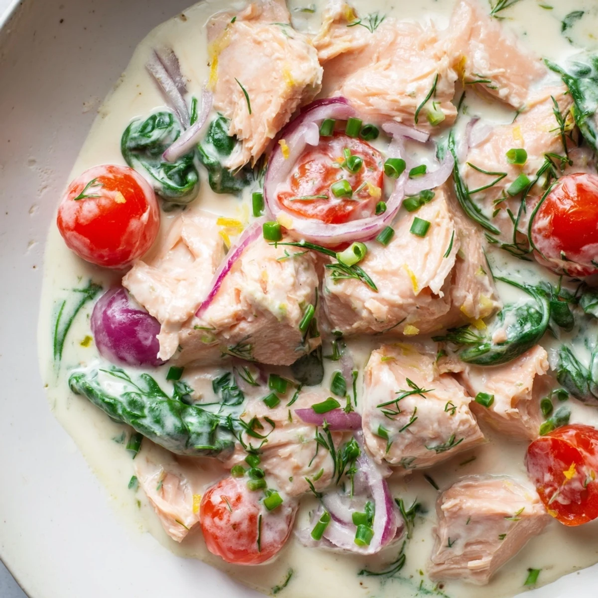 Bowl of creamy leftover salmon recipe served over fluffy quinoa with fresh dill