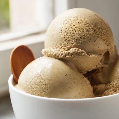 Hojicha Ice Cream rests in a chilled bowl, featuring a smooth, warm brown texture and inviting aroma.