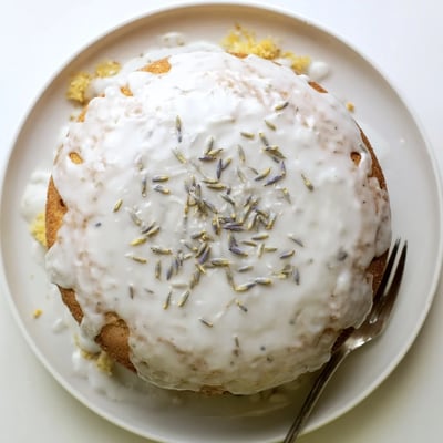Freshly baked Lemon Lavender Cake with vibrant lemon zest and subtle floral lavender garnish on plate.