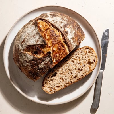 Crusty sourdough bread sliced open revealing a soft chewy interior crumb